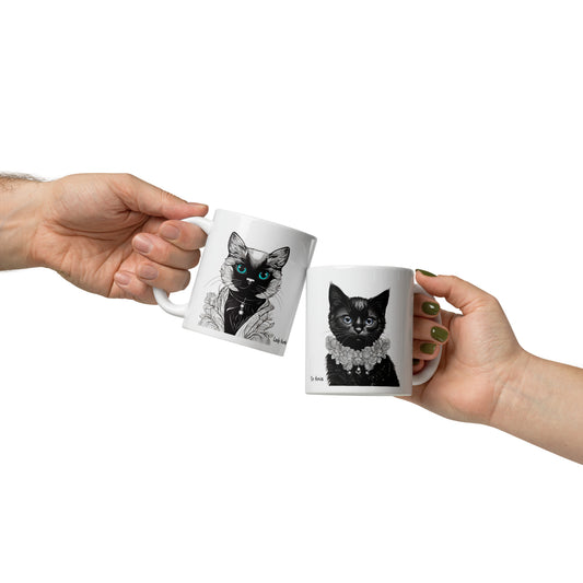 Two hands holding royal cat coffee mugs: one displaying a royal cat lady design and the other featuring a royal cat lord design, showing their front views.