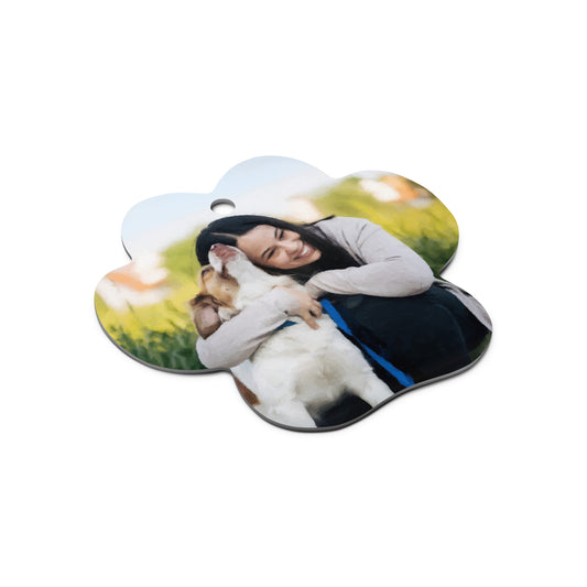 Side view of a custom pet ornament featuring a portrait of a woman and her dog in a paw-shaped lightweight ornament, showing the thickness.