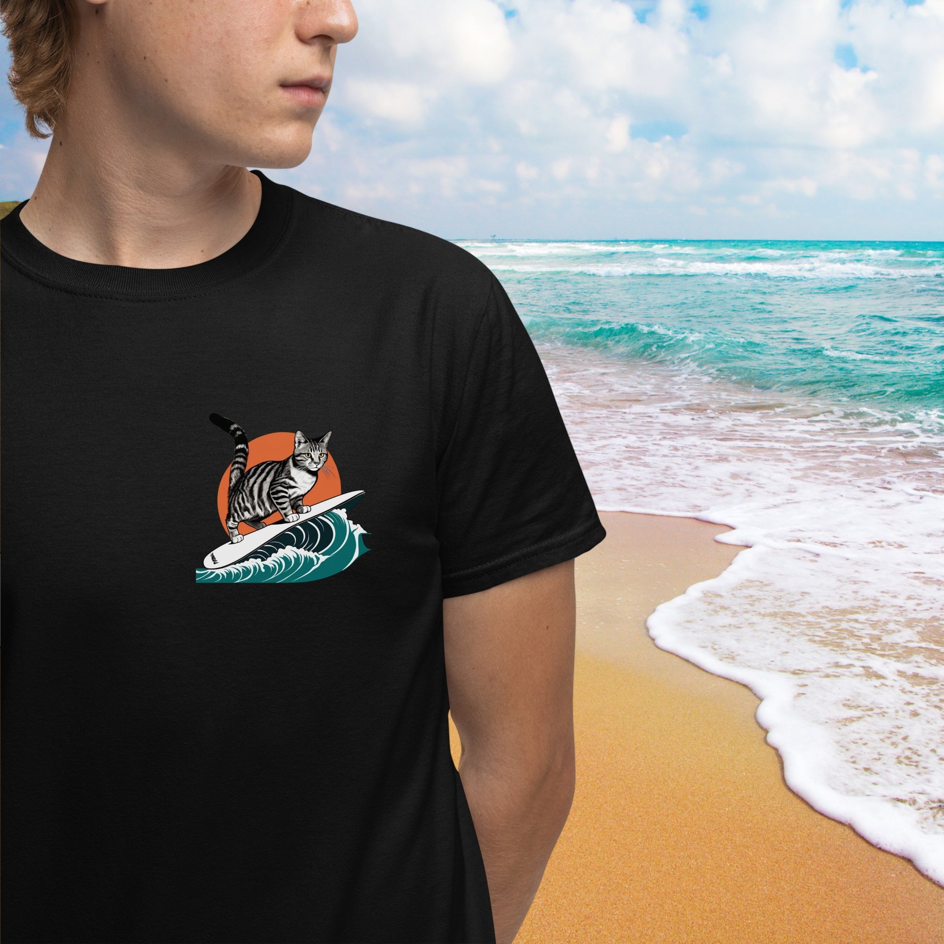 Close-up of a young man wearing a black minimalist graphic t-shirt, featuring a small surfing cat design on the front left chest. A cool and subtle cat shirt for men.
