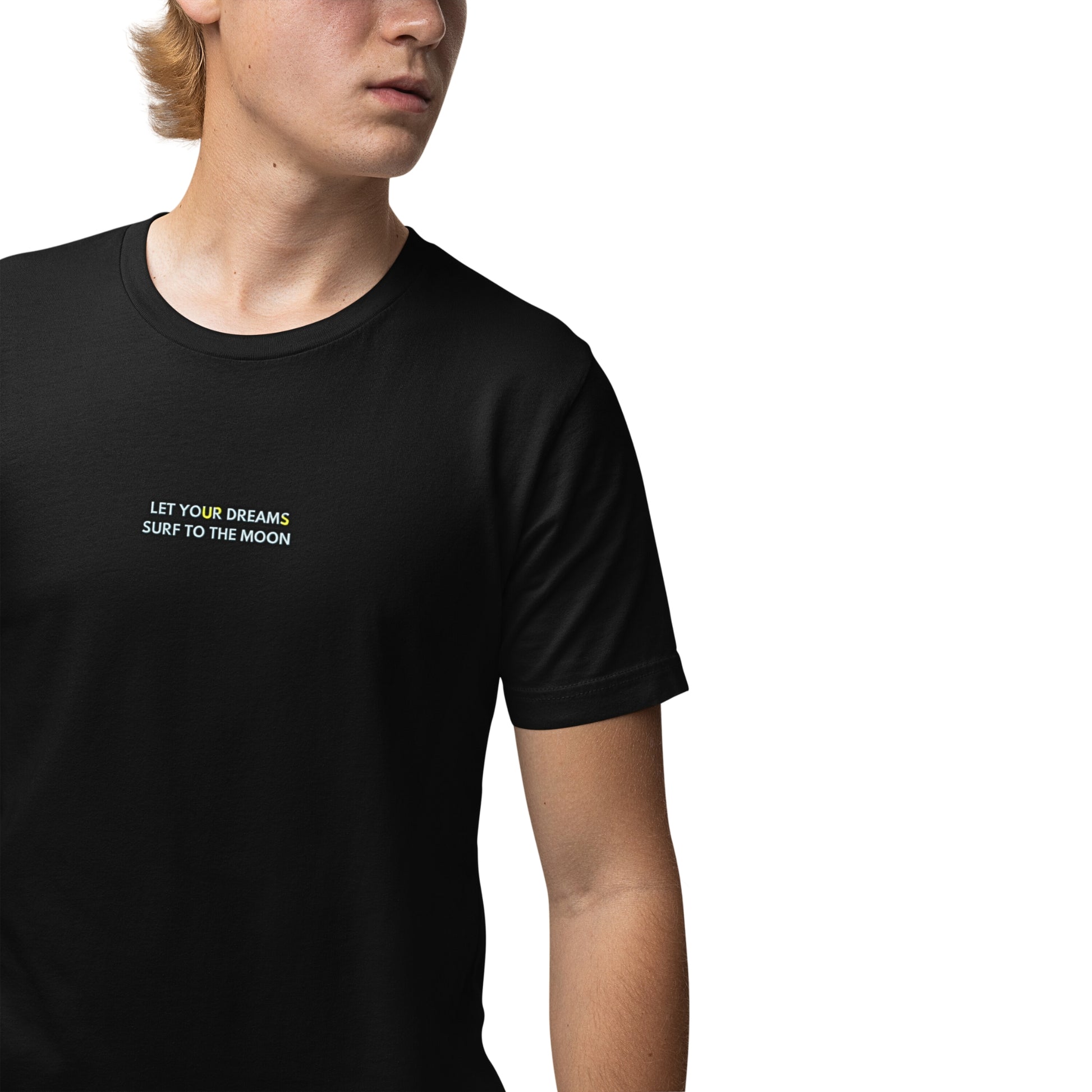 A young man wearing a black color cotton T-shirt with a 'Let Your Dreams Surf to the Moon' graphic on the front.