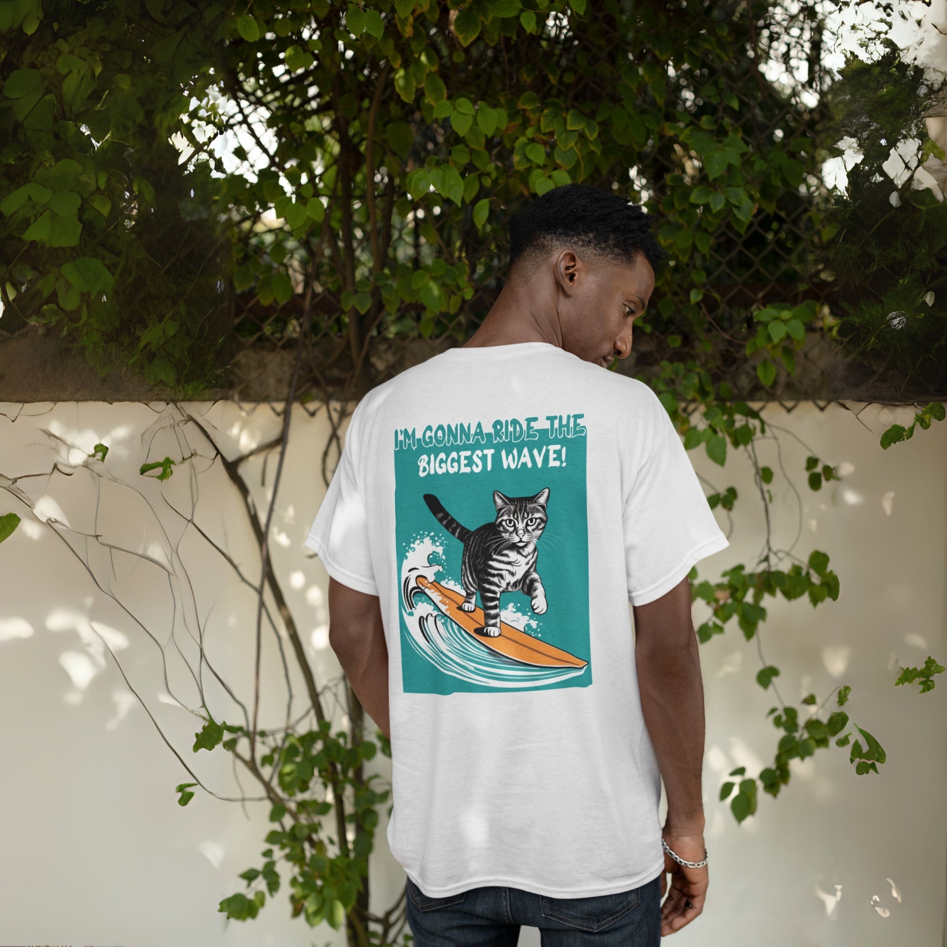 Back view of a young man wearing a cat funny t-shirt – a grey cotton tee featuring a playful graphic of a waving cat and the text: 'I'm gonna ride the biggest wave.' A cool and humorous design for cat lovers.