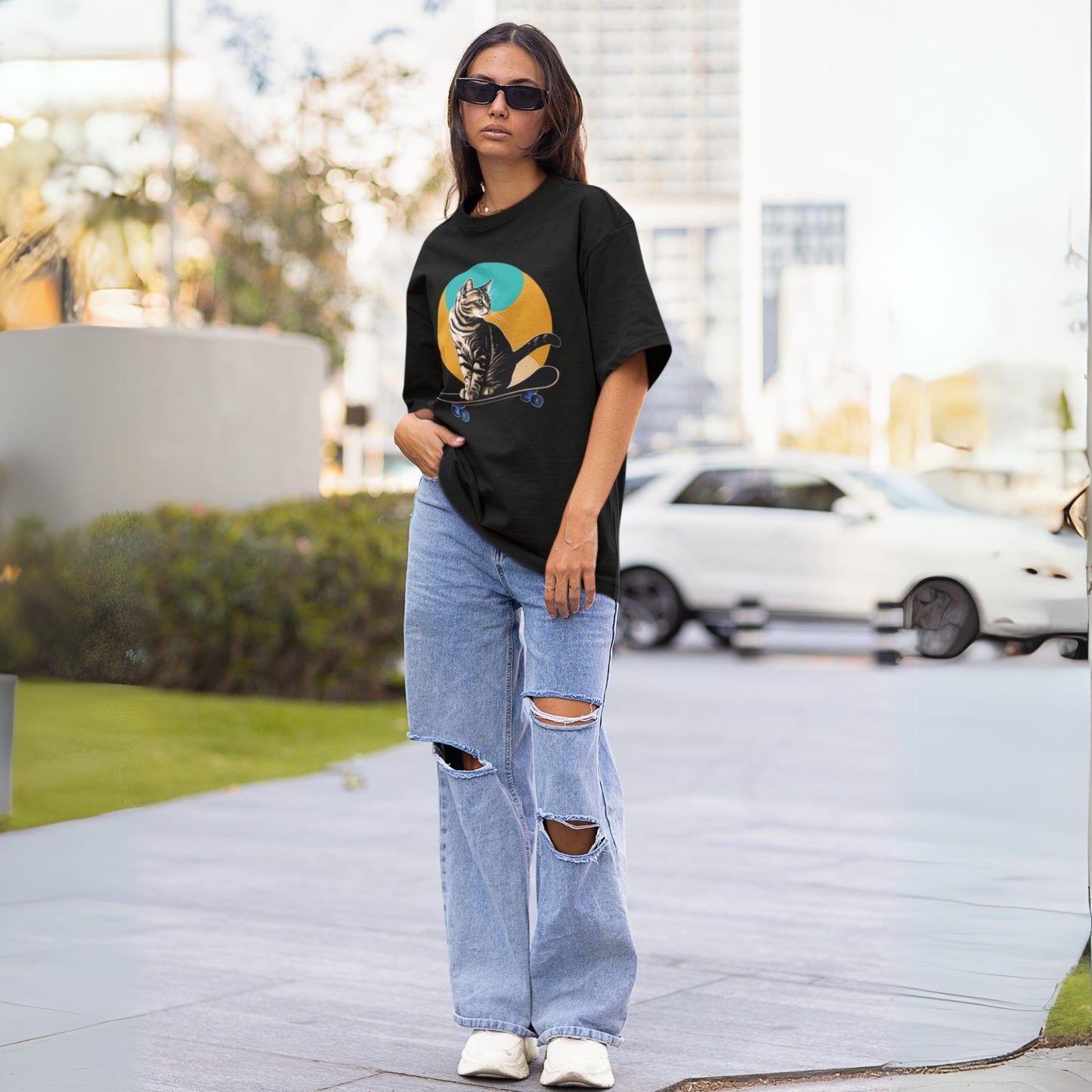 Full view of a young woman wearing a black short-sleeve cool cat shirt with a playful skateboarding cat graphic, highlighting a fun and casual style.