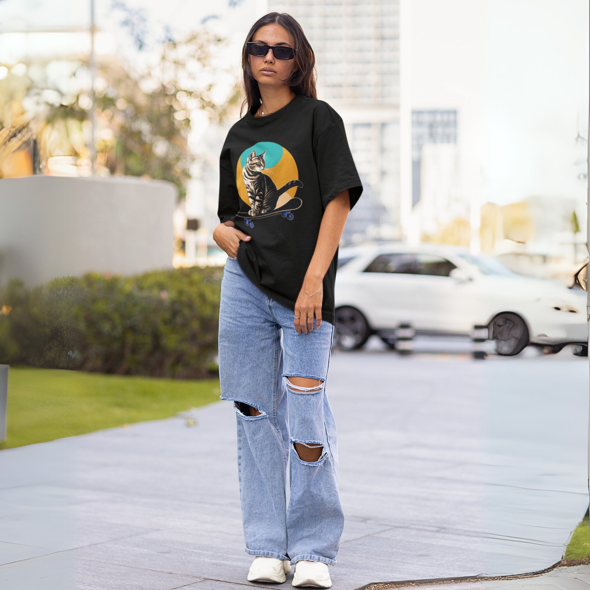 Full view of a young woman wearing a black short-sleeve cool cat shirt with a playful skateboarding cat graphic, highlighting a fun and casual style.