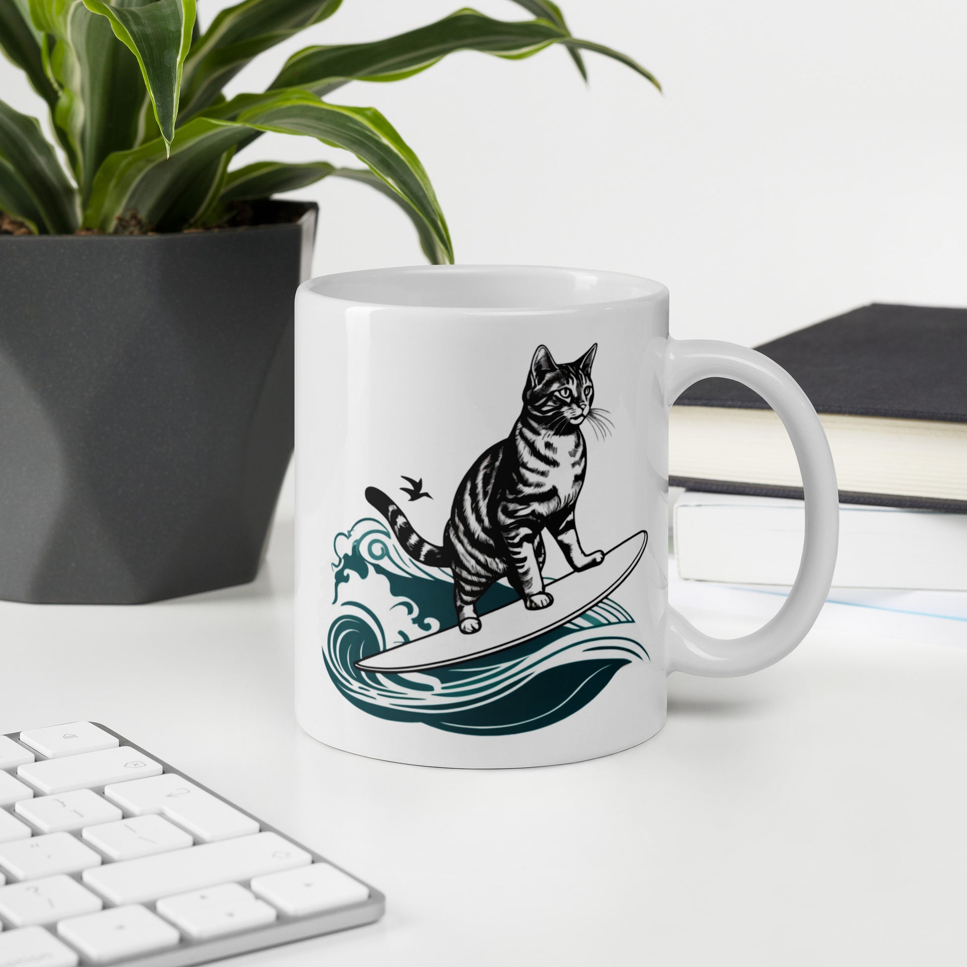 A sleek, white glossy mug adorned with a playful surfing cat graphic, set against the background of a modern office workspace.