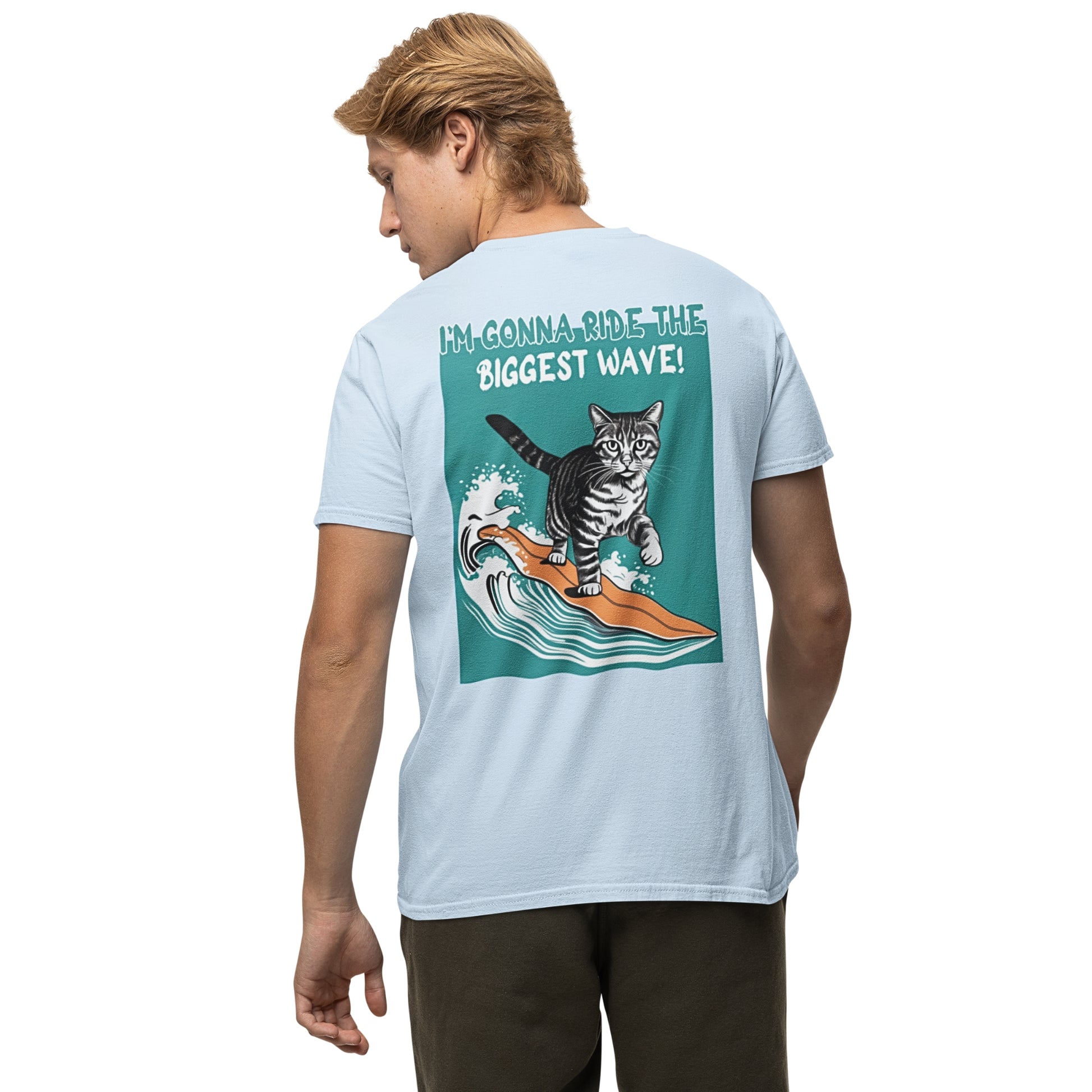 Back view of a young man wearing a light blue cotton cat funny t-shirt, featuring a playful graphic of a waving cat and the text: 'I'm gonna ride the biggest wave.' A cool and humorous design for cat lovers.
